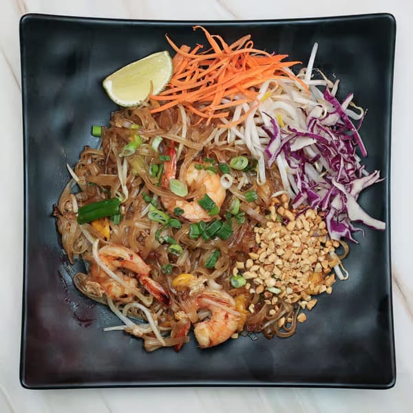 Krungthep Thai and Pho's Pad See Ew with shrimp, lime, shredded carrots, bean sprouts, and peanuts.